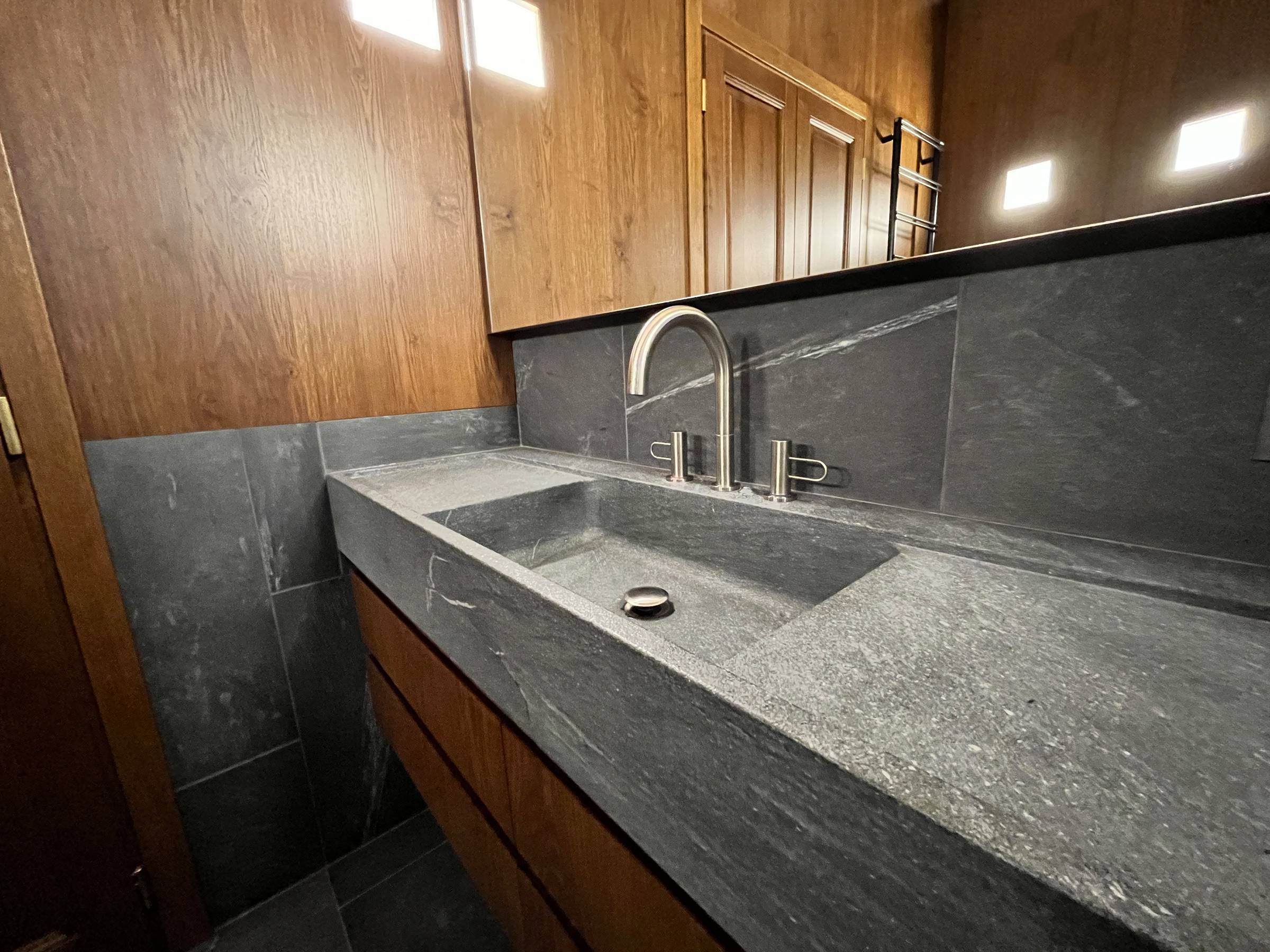 Continuità sartoriale: le sale da bagno su misura coordinate alle porte in massello della residenza. — 