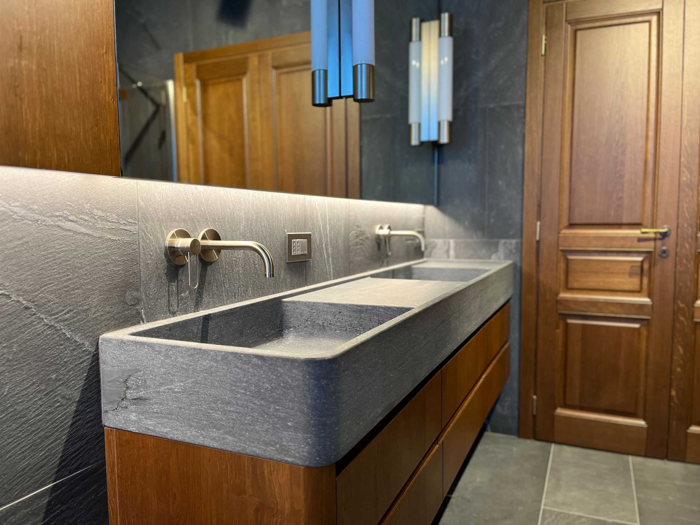 Continuità sartoriale: le sale da bagno su misura coordinate alle porte in massello della residenza. — 