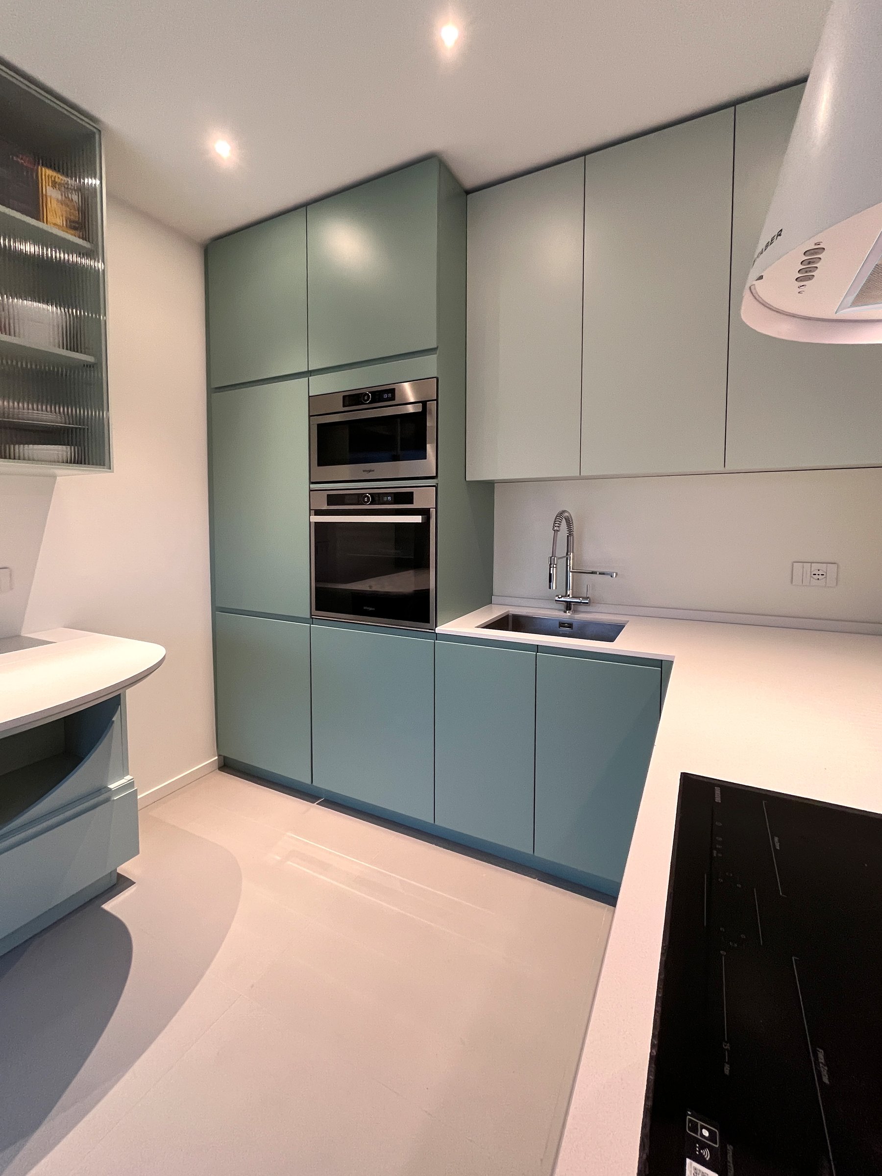 Cucina moderna su progetto con laccatura opaca e parete in vetro cannettato — 