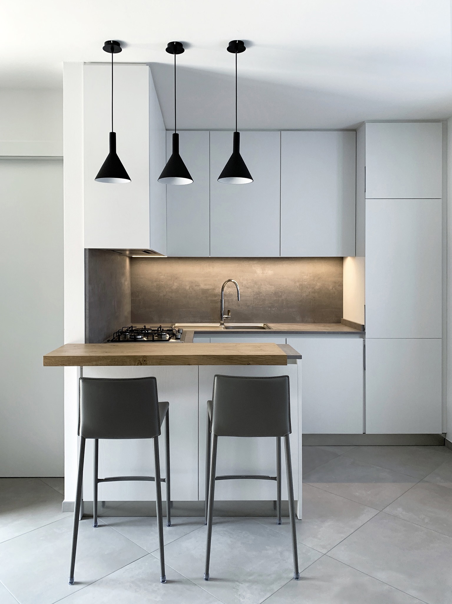 Bergo Arredi — Cucina su misura ad angolo con penisola cemento e bianco: armonia tra design moderno e funzionalità