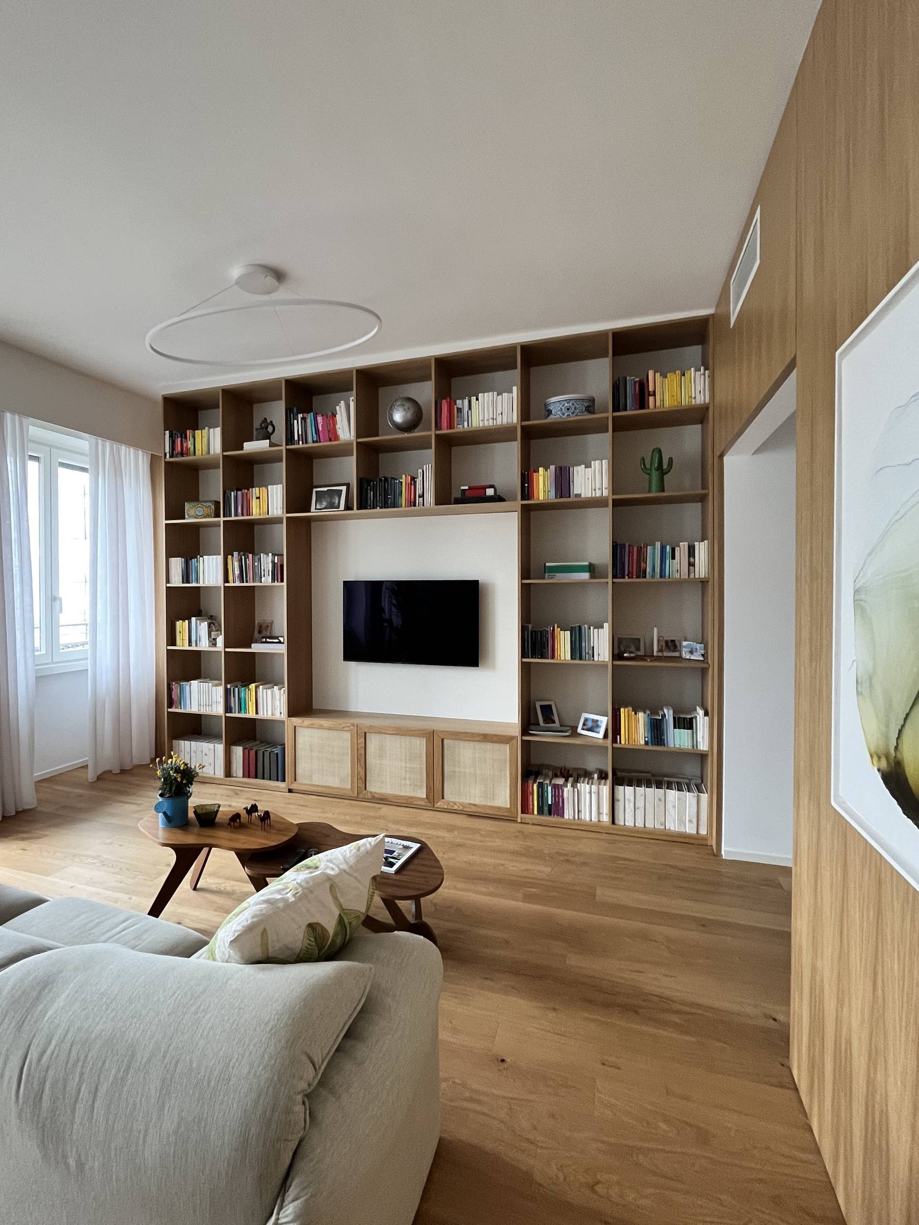 L'arte del dettaglio: la libreria su misura in Rovere Naturale con ante in paglia di Vienna. — 
