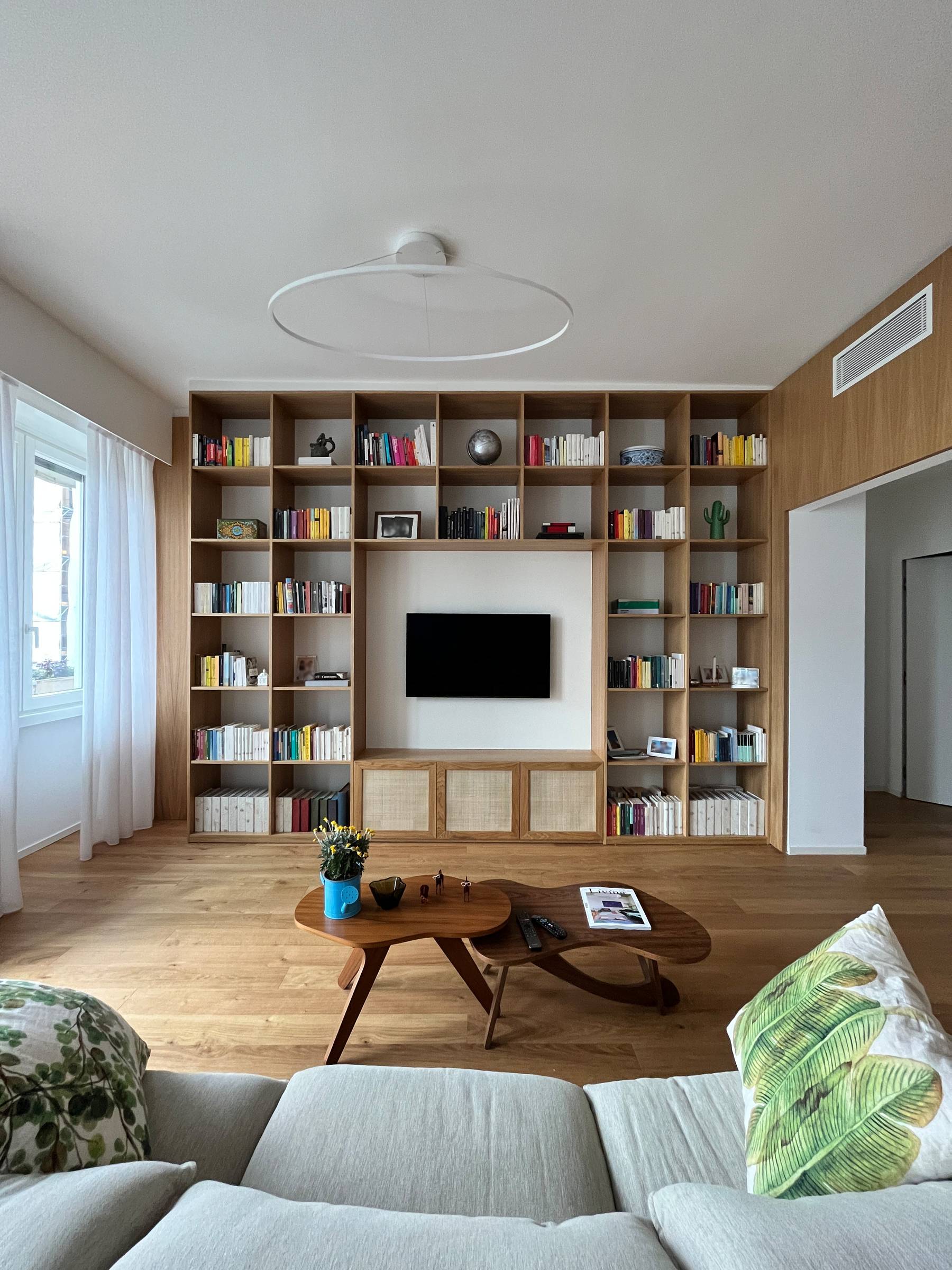Bergo Arredi — L'arte del dettaglio: la libreria su misura in Rovere Naturale con ante in paglia di Vienna.