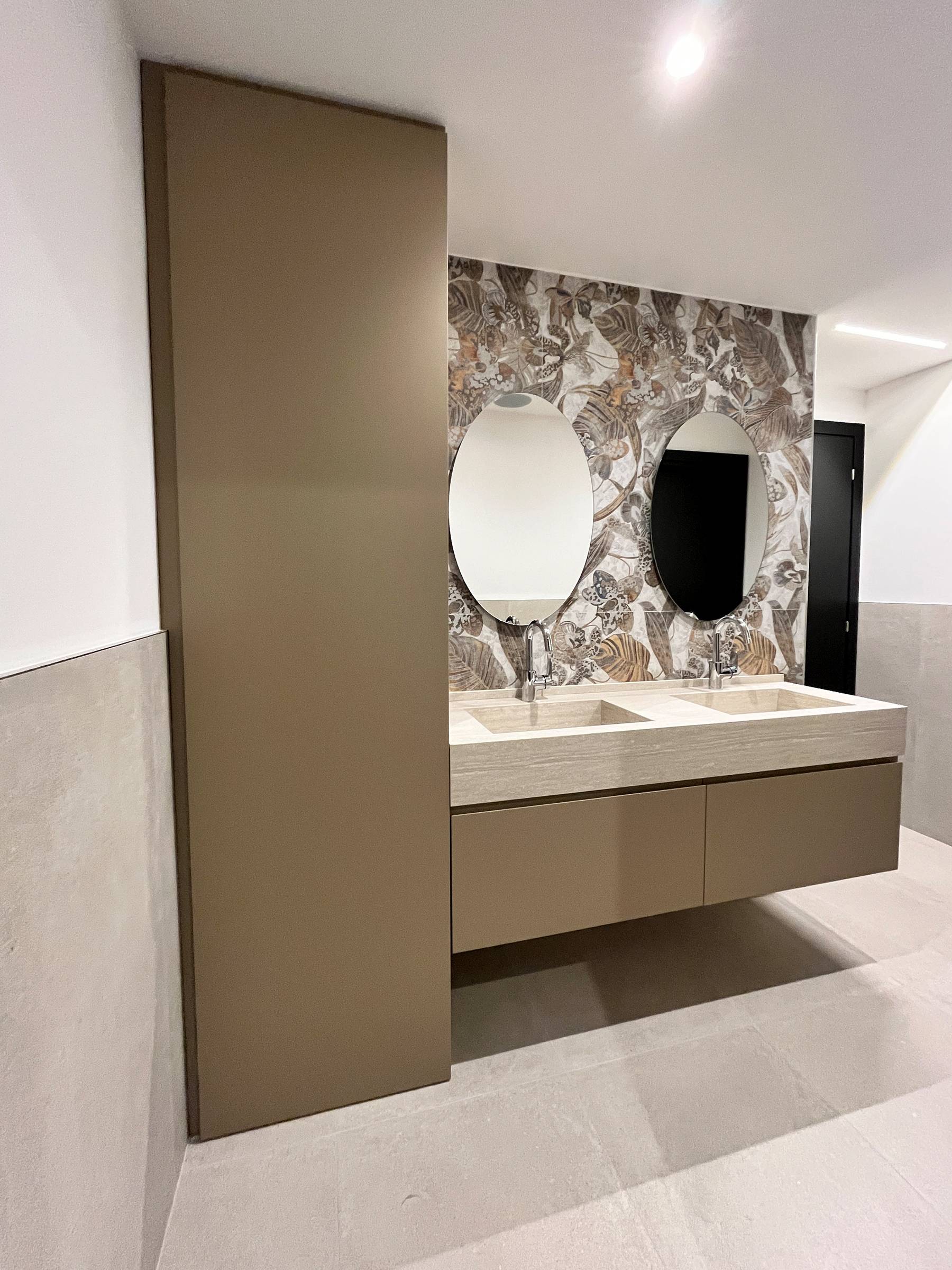 L'estetica del monolite: il bagno sartoriale in HPL Travertino e gola integrata. — 